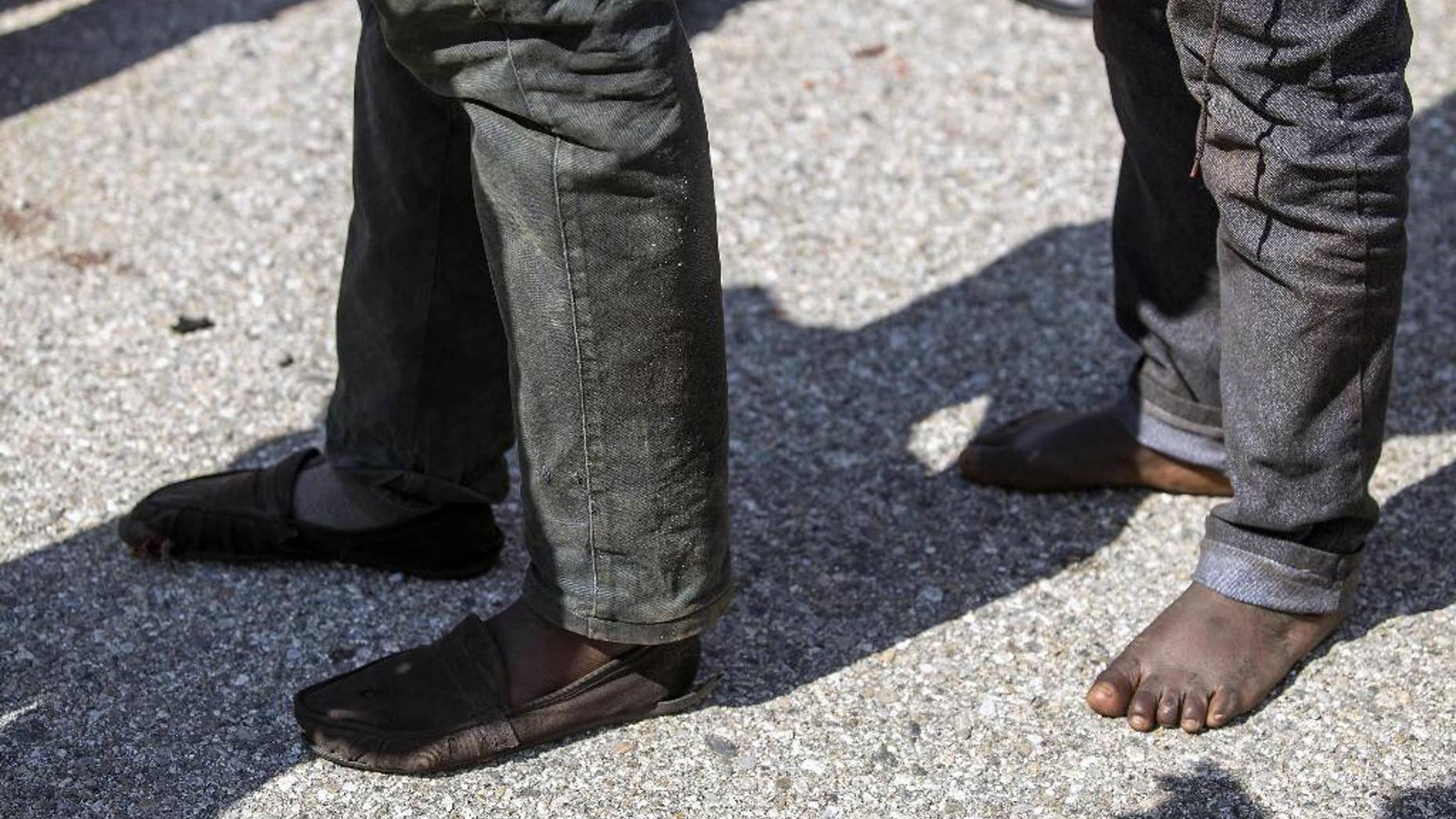 Rescued migrants line up after disembarking at the southern Italian port of Corigliano, Italy, Wednesday, April 15, 2015. Survivors of a capsized migrant boat off Libya have told Tuesday, April 14, the aid group Save the Children that an estimated 400 people are believed to have drowned. Even before the survivors were interviewed, Italy's Coast Guard said it assumed that there were many dead given the size of the ship and that nine bodies had been found. (Francesco Arena, ANSA via AP)