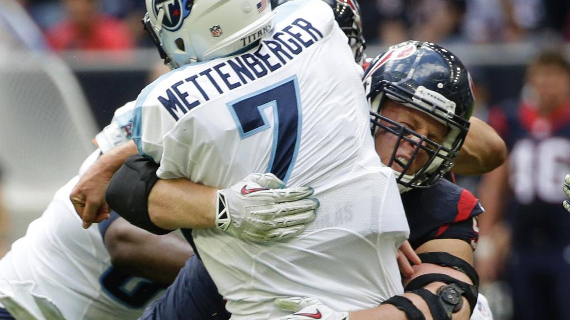 Houston Texans defensive end J.J. Watt tackles Tennessee Titans quarterback Zach Mettenberger (7) during the first half of an NFL football game Sunday, Nov. 30, 2014, in Houston. (AP Photo/David J. Phillip)