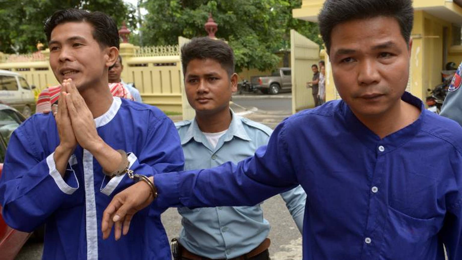Born Samnang (left) and Sok Sam Oeun (right) are escorted by a prison guard to the Supreme Court in Phnom Penh, on September 25, 2013.