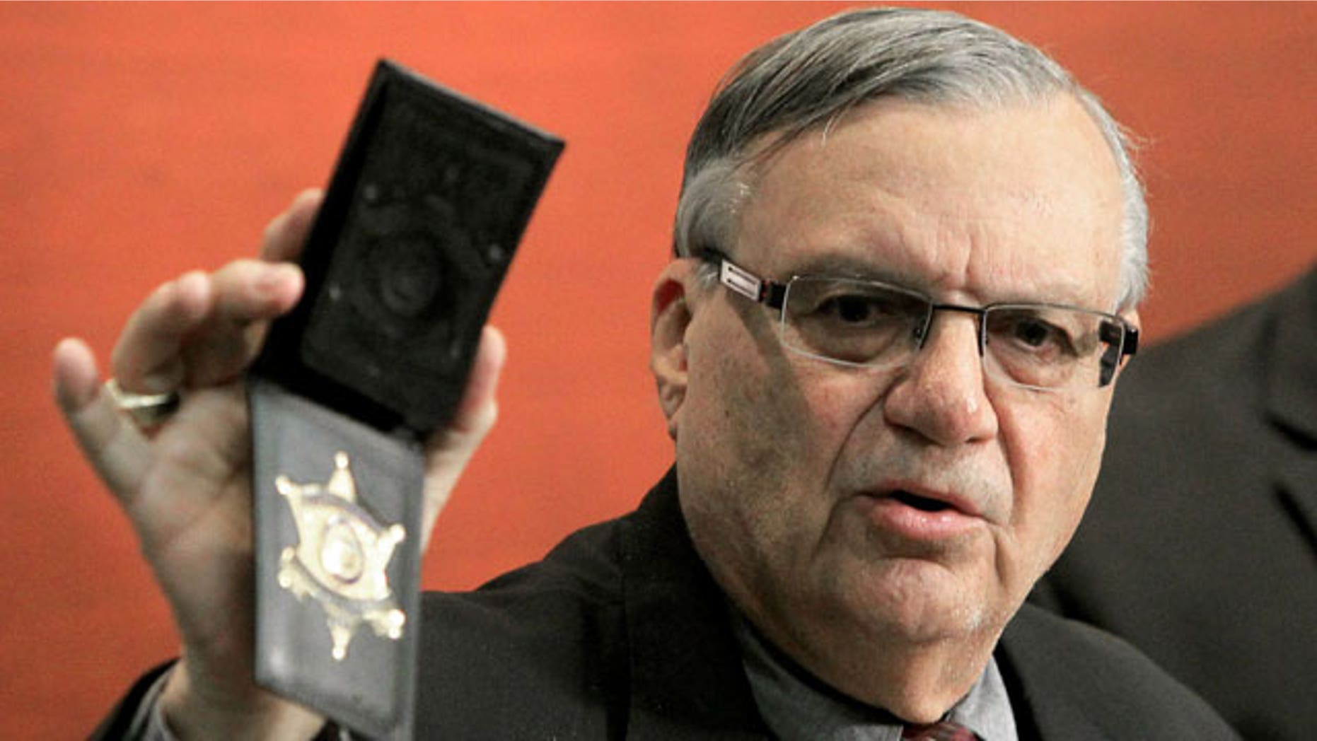 December 21, 2011: Maricopa County Sheriff Joe Arpaio shows his badge as he holds a ceremony where 92 of his immigration jail officers, who lost their federal power to check whether inmates are in the county illegally, turn in their credentials after federal officials pulled the Sheriff's office immigration enforcement powers in Phoenix.