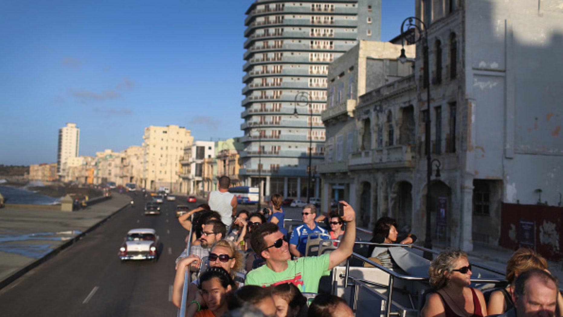 Tourists take in the sites from a double decker tour bus of Havana.