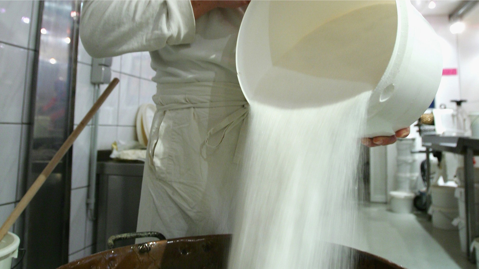 BERLIN - OCTOBER 12: Hjalmar pours out sugar in a boiling pot on October 12, 2007 in Berlin, Germany. The Berlin based candy store produces 30 different kinds of handmade candies according traditional recipes. (Photo by Andreas Rentz/Getty Images)