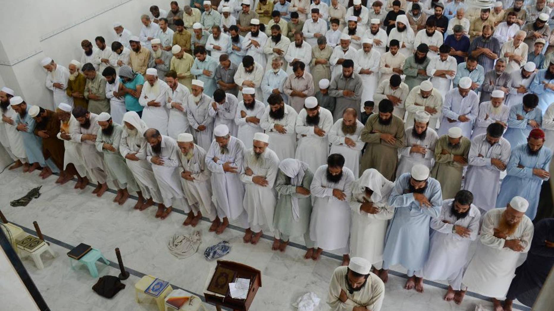 People offer funeral prayers for Taliban leader Mullah Mohammad Omar at a mosque in Peshawar, Pakistan, Friday, July 31, 2015. Afghanistan's Taliban on Thursday confirmed the death of Mullah Omar, who led the group's self-styled Islamic emirate in the 1990s, sheltered al-Qaida through the 9/11 attacks and led a 14-year insurgency against U.S. and NATO troops. (AP Photo/Mohammad Sajjad)