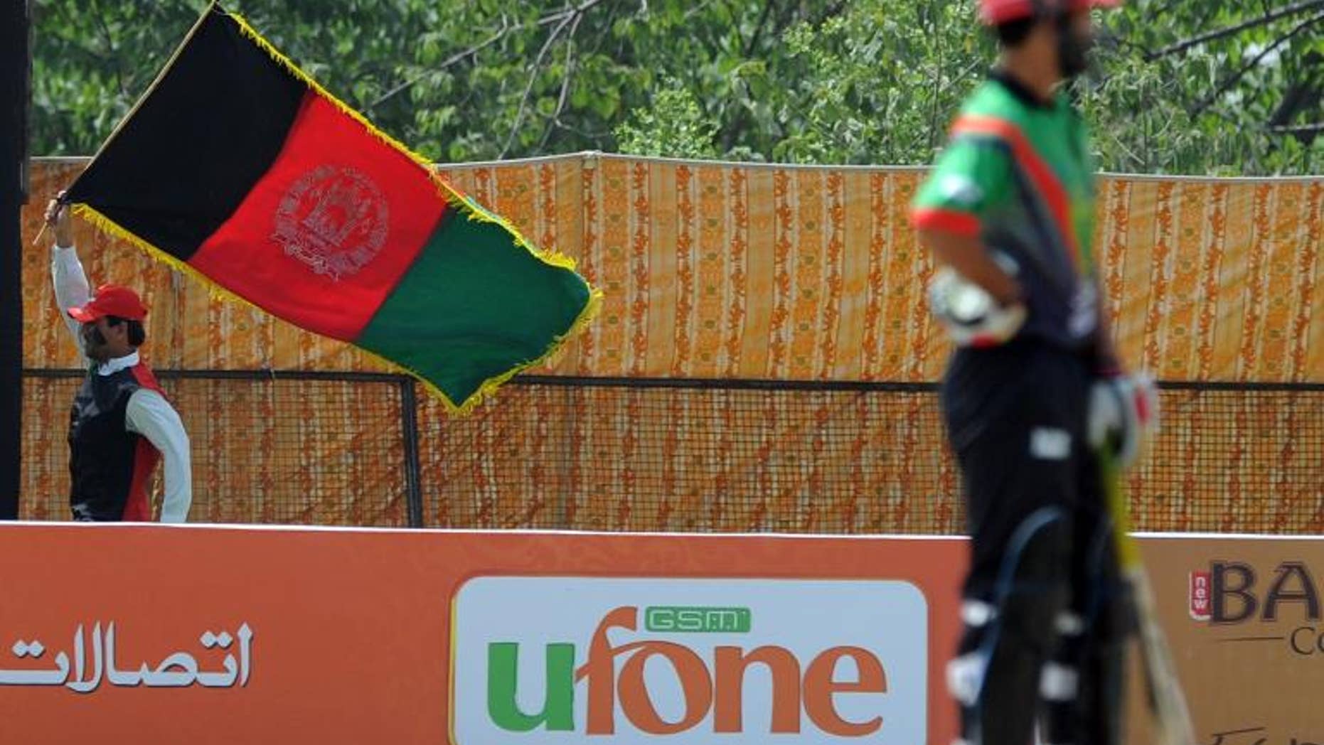 An Afghan cricket fan waves his national flag as he cheers for his team at a local ground in Islamabad on May 25, 2011.
