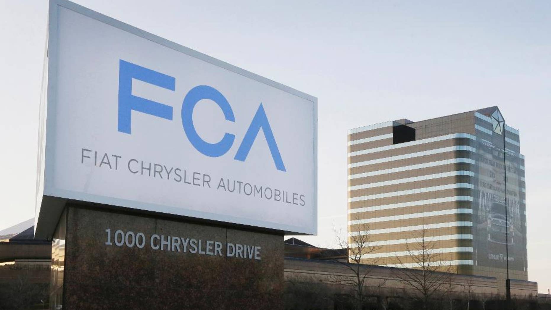 FILE - This Tuesday, May 6, 2014, file photo shows a sign outside Fiat Chrysler Automobiles world headquarters in Auburn Hills, Mich. Fiat Chrysler and Google said Tuesday, April 25, 2017, for the first time will offer rides to the public in the self-driving automobiles they are building under an expanding partnership. (AP Photo/Carlos Osorio, File)