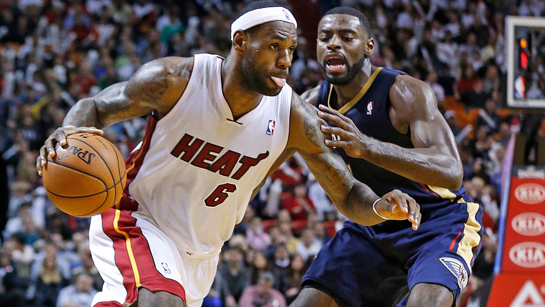 Miami Heat's LeBron James (6) drives to the basket against New Orleans Pelicans’ Tyreke Evans (1) during the second half of an NBA basketball game in Miami, Tuesday, Jan 7, 2014. The Heat defeated the Pelicans 107-88. (AP Photo/Joel Auerbach)
