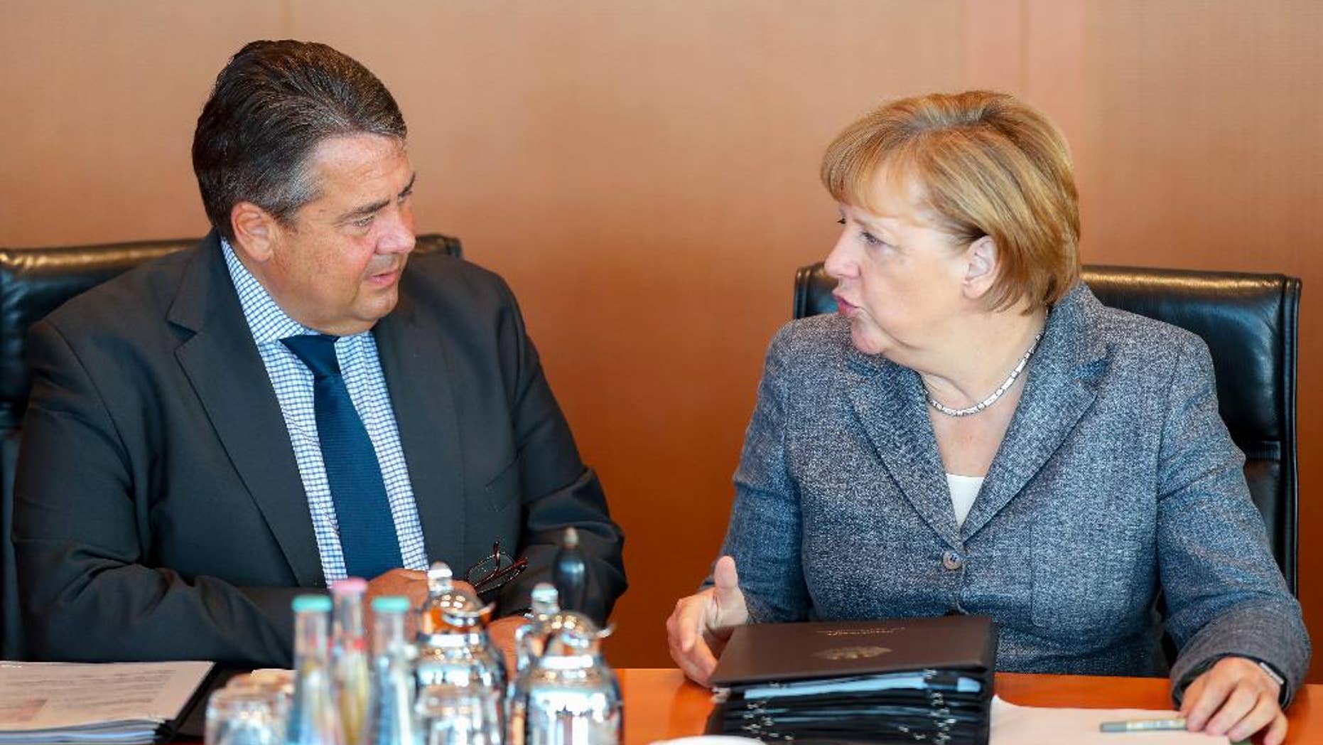 German Chancellor Angela Merkel, right, and German Economics Minister Sigmar Gabriel attend a cabinet meeting at the chancellery in Berlin, Germany, Wednesday Aug. 17, 2016. (Kay Nietfeld/dpa via AP)