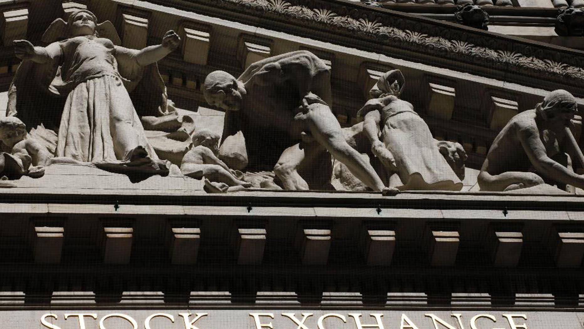 FILE - This March 4, 2013 file photo shows a sign for Wall Street on the side of building near the New York Stock Exchange, in New York. U.S. stocks are opening lower Tuesday, Sept. 23, 2014, following disappointing economic news and U.S.-led airstrikes against Islamic State militants in Syria. (AP Photo/Mark Lennihan, File)