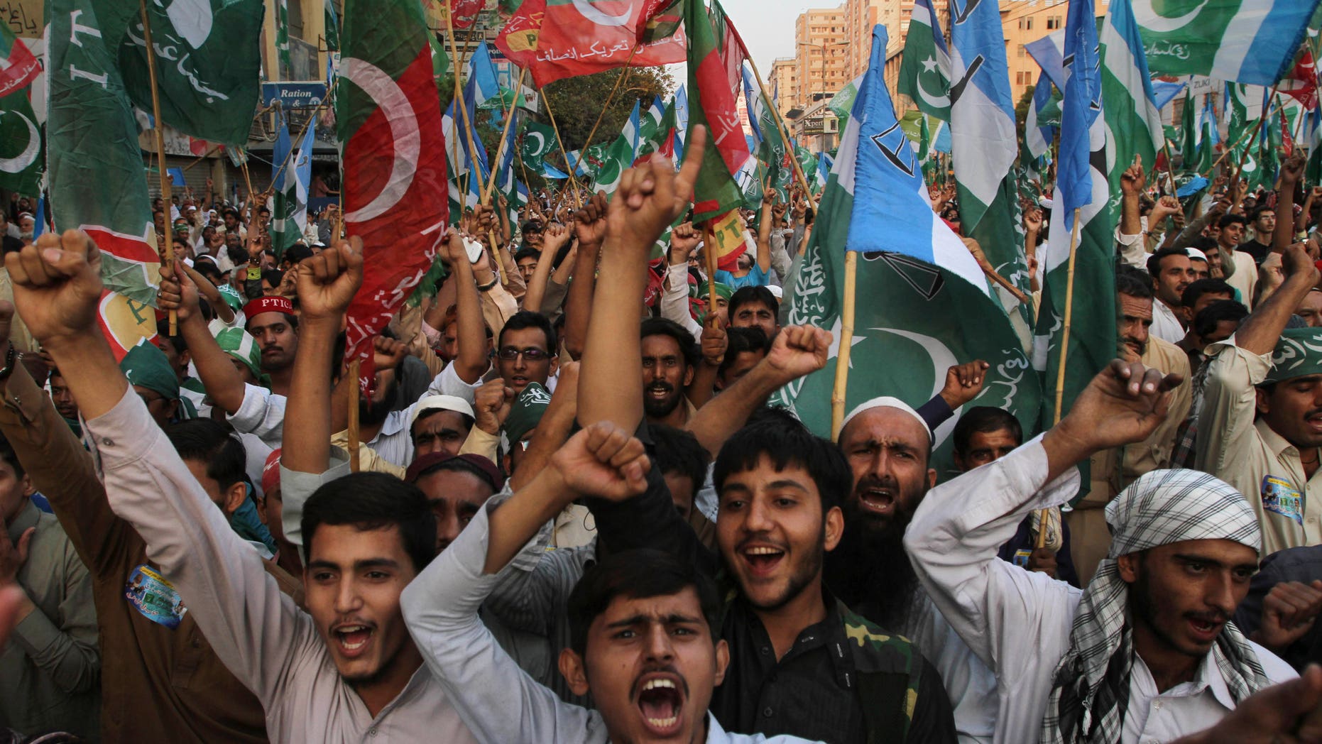 Supporters of the Pakistani religious party Jammat-e-Islami and Tehreek-e-Insaf party, headed by cricketer-turned politician Imran Khan, hold up their parties' flags and chant slogans during a rally against U.S. drone strikes in Pakistani areas, in Karachi, Pakistan, Sunday, Nov. 24, 2013. (AP Photo/Fareed Khan)