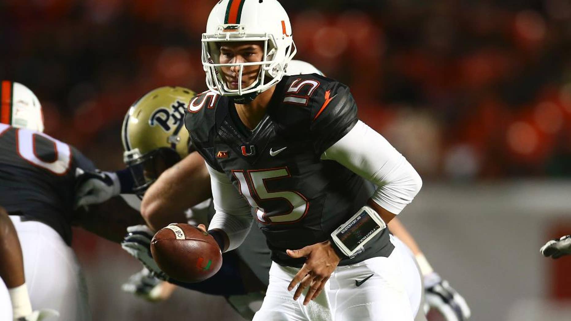 Miami quarterback Brad Kaaya runs plays against Pittsburgh during the first half of an NCAA college football game in Miami Gardens, Fla., Saturday, Nov. 29, 2014. (AP Photo/J Pat Carter)