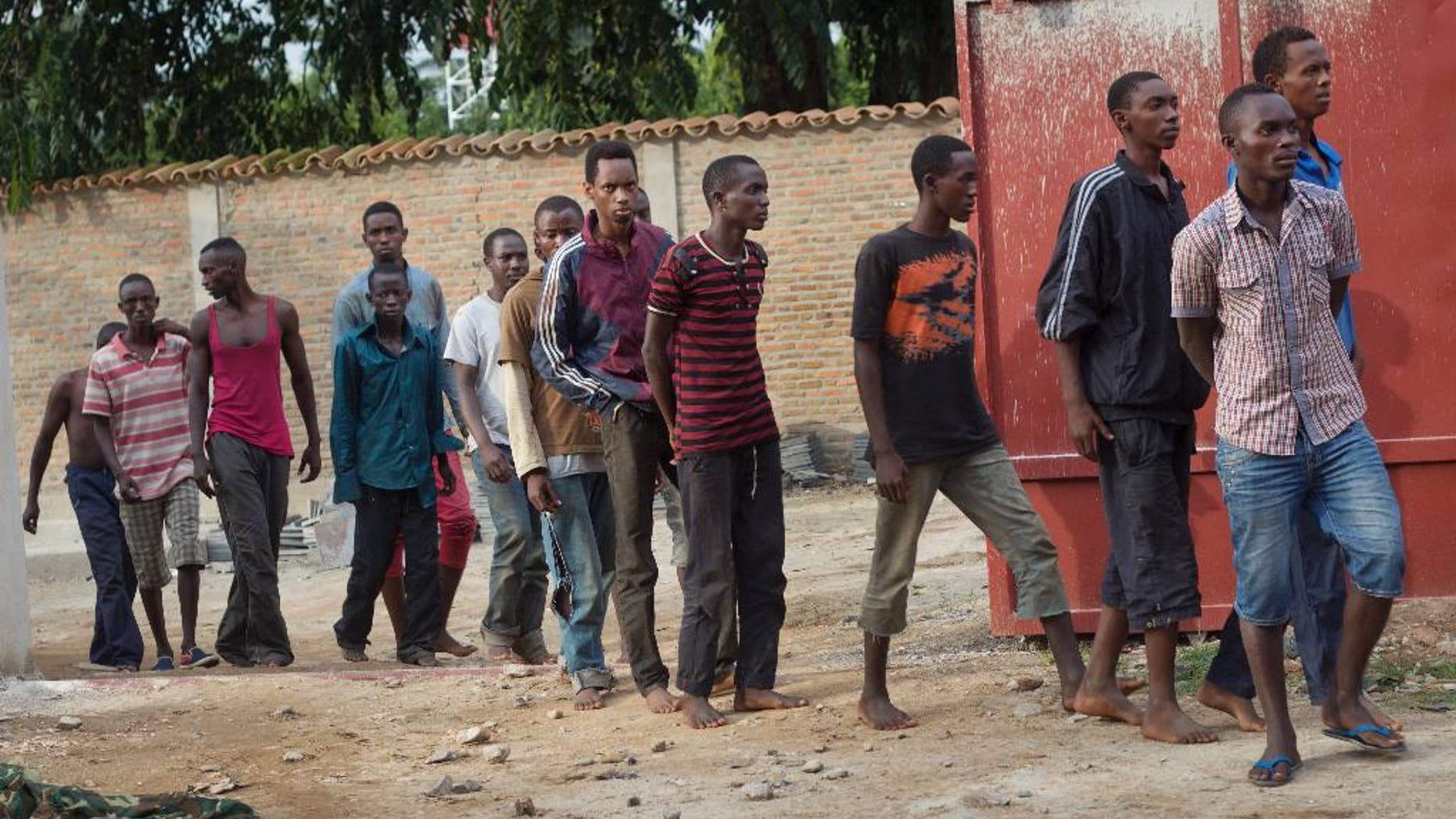 Men captured by the security forces, who were said by them to have been involved in Friday's attacks on military targets but which could not be independently verified, are paraded during a press conference at the country's intelligence service headquarters in the capital Bujumbura, Burundi, Saturday, Dec. 12, 2015. Violence from coordinated attacks on three army installations killed 87 people, an army spokesman said Saturday, while in the Nyakabiga neighborhood residents said they woke up to the shocking scene of dead bodies sprawled out on the streets, some of whom had their hands tied behind their backs. (AP Photo/Melanie Gouby)