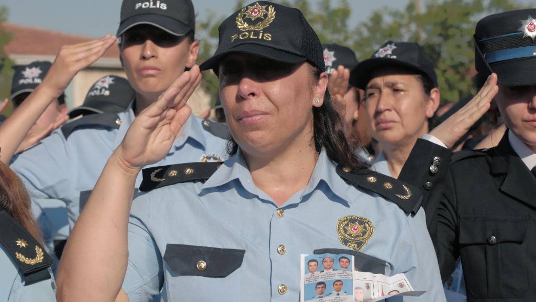FILE - In this July 17, 2016 file photo, female police officers attend a funeral ceremony for colleagues killed during a failed military coup, in Ankara, Turkey. Turkey's official gazette says female police officers will be able to wear headscarves as part of their uniform. The ruling published over the weekend, Aug. 27-28, 2016, says the policewomen can wear headscarves under their caps or berets on condition they be the same color as the uniform and without a pattern.(AP Photo/Burhan Ozbilici, File)
