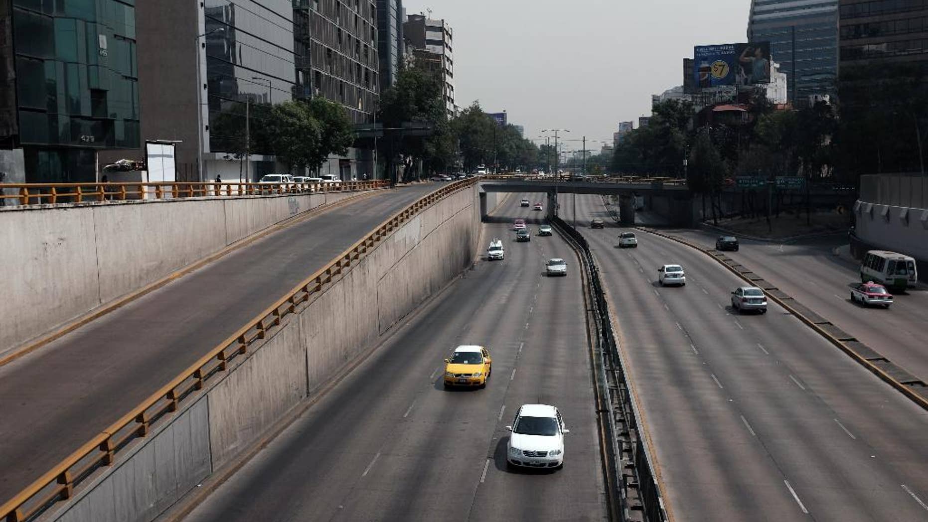 Cars drive along what would usually be a very busy thoroughfare in Mexico City, Wednesday, April 6, 2016. City authorities have barred millions of vehicles from the streets due to a pollution alert. (AP Photo/Dario Lopez-Mills)