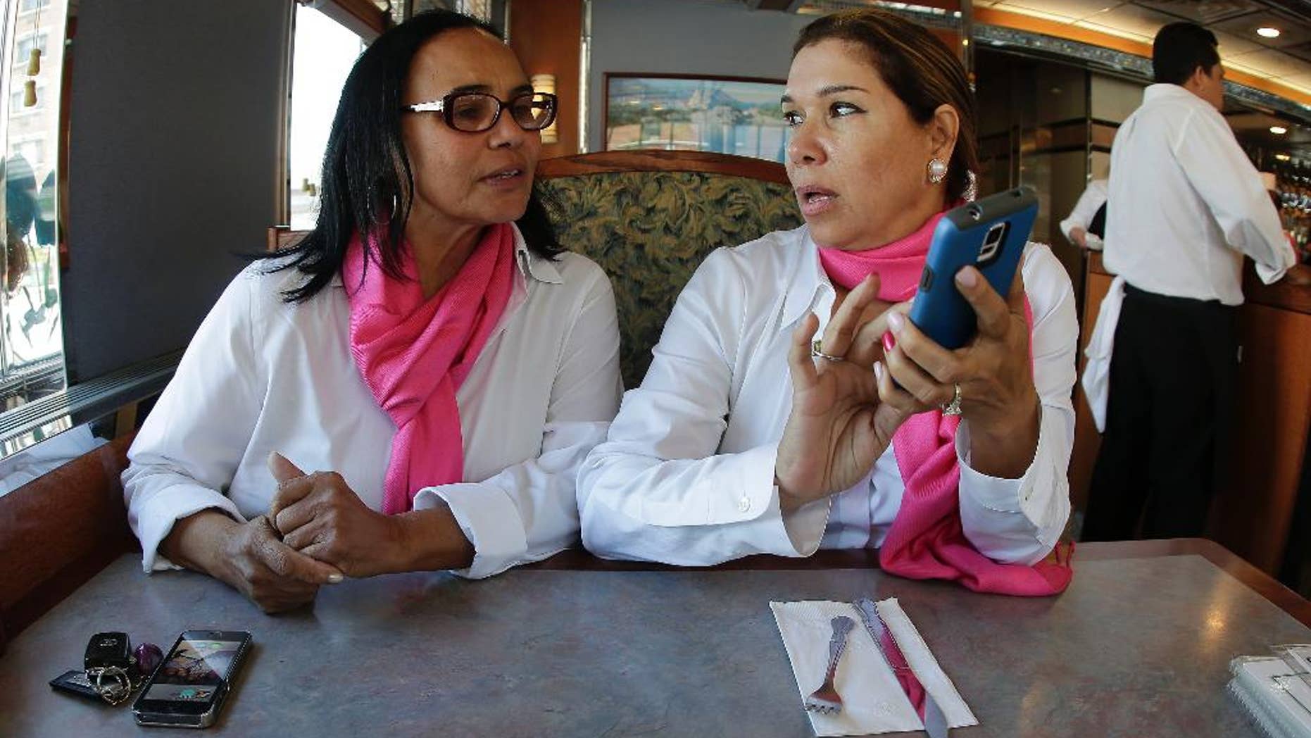Dinorah De Cruz, left, talks with Stella Mateo, founder of the SheTaxi/SheRides car service, while taking a lunch break, Monday, Sept. 15, 2014, in New York.