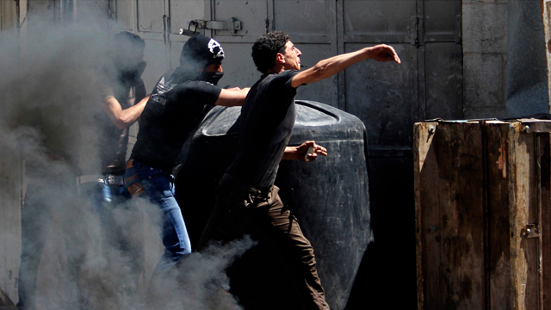 April 2, 2013: Palestinians throw stones at Israeli soldiers after the death of Maysara Abu Hamdiyeh in Israeli jail in the West Bank city of Hebron.