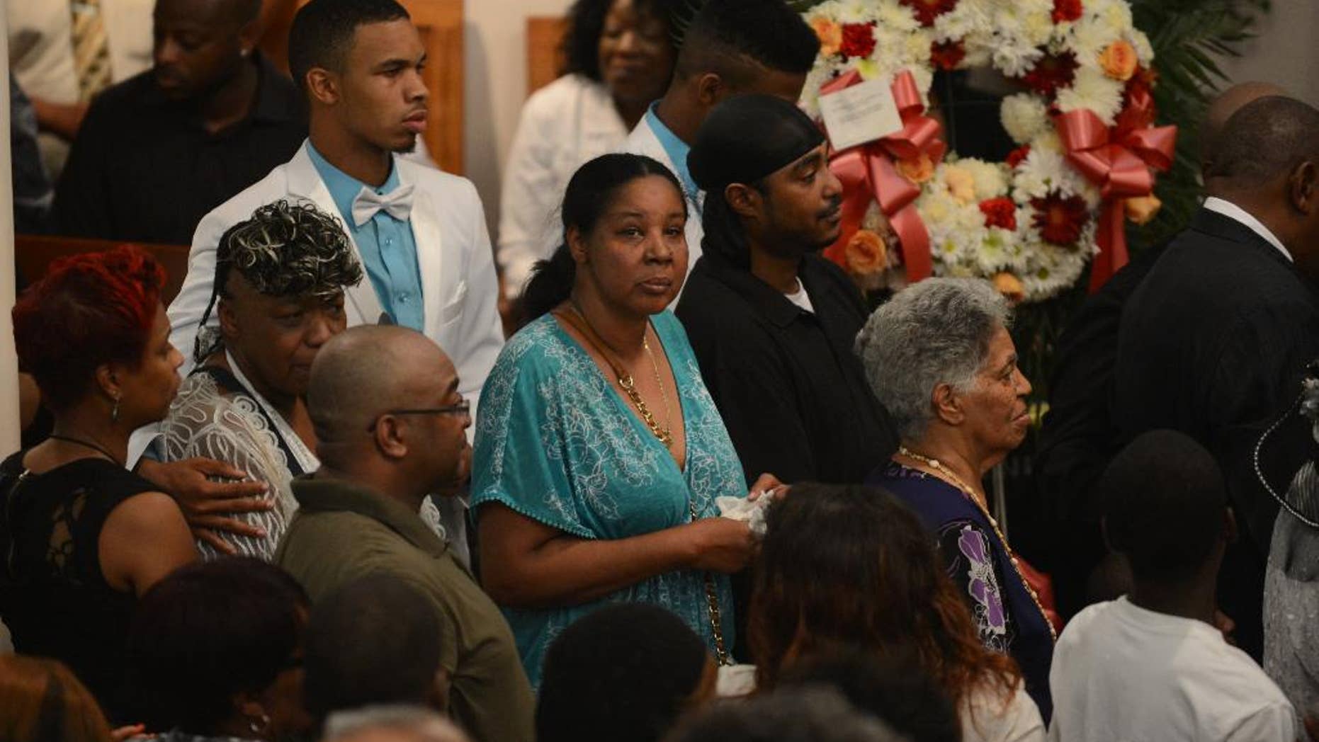 Esaw Garner, center, is followed by Gwendolyn Flagg-Carr, mother of Eric Garner, and Eric Snipes Garner, Jr., son of Eric Garner, during funeral services for her Eric Garner, at Bethel Baptist Church in the Brooklyn borough of New York Wednesday, July 23, 2014. Garner's death while in police custody has led to accusations of police misconduct. (AP Photo/The Daily News, Julia Xanathos, Pool)