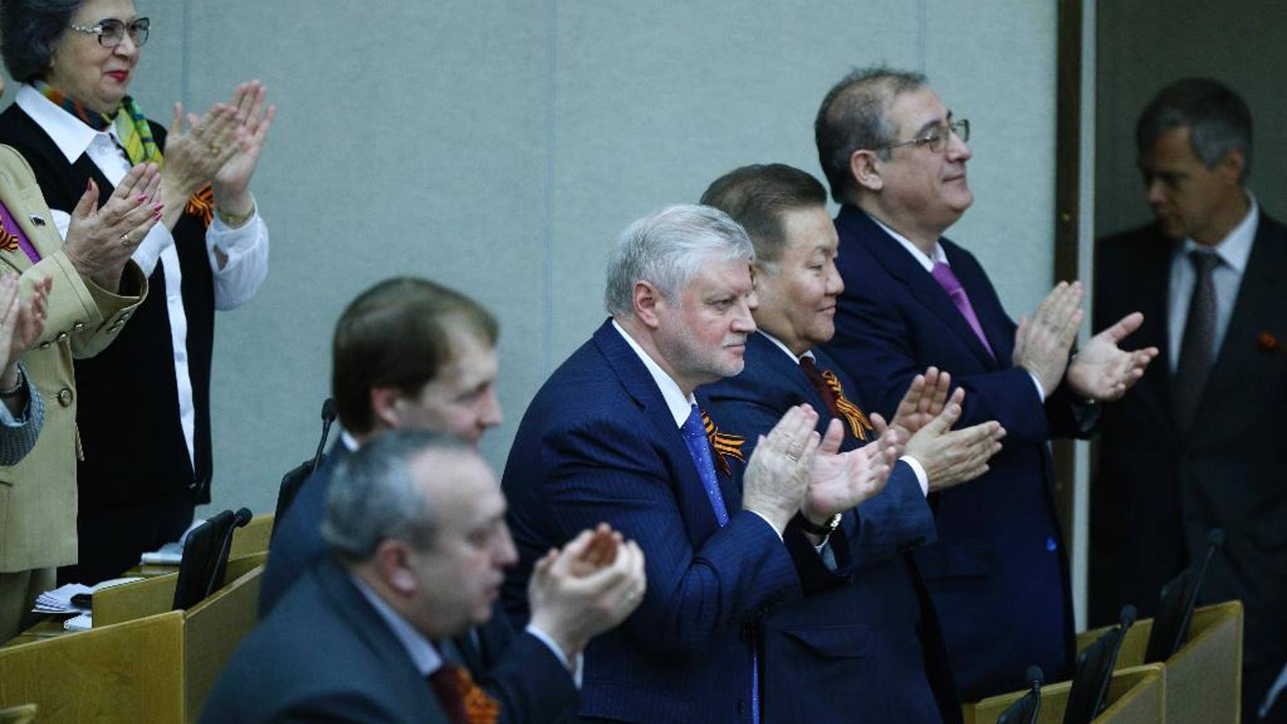 Members of the State Duma, lower parliament chamber, applaud for their voting during a plenary session in Moscow, Russia, Thursday, March 20, 2014. The Kremlin-controlled State Duma voted Thursday to allow Crimea to join Russia following a quick discussion in which members of the Kremlin-controlled chamber assailed the Ukrainian authorities. The merger needs to be rubber stamped by the upper house and signed by President Vladimir Putin, mere formalities expected to be completed by the end of the week. (AP Photo/Alexander Zemlianichenko)