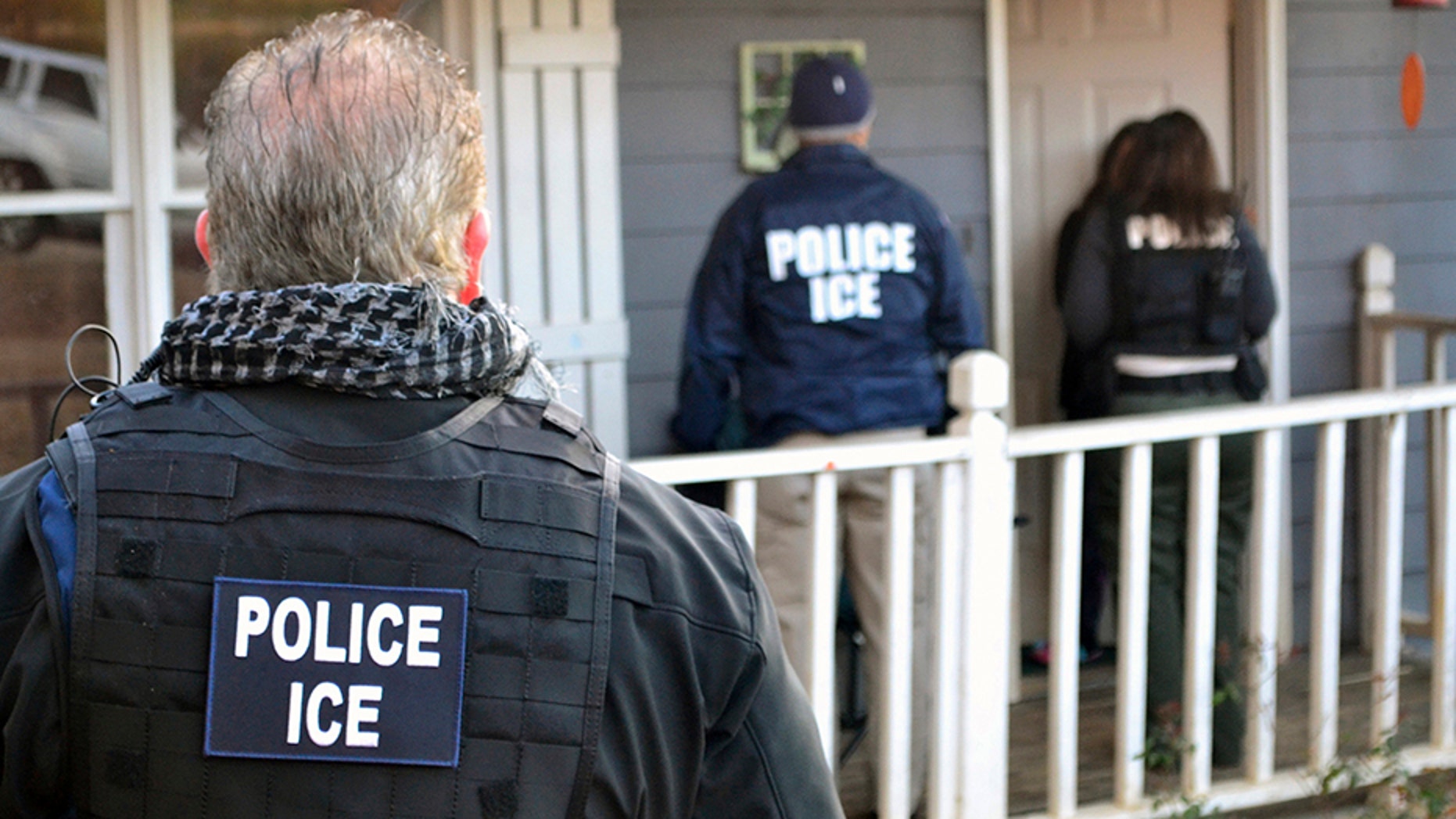 In this Feb. 9, 2017, file photo provided by U.S. Immigration and Customs Enforcement, ICE agents stand outside a home in Atlanta during a targeted enforcement operation aimed at immigration fugitives, re-entrants and at-large criminals living in the country illegally.