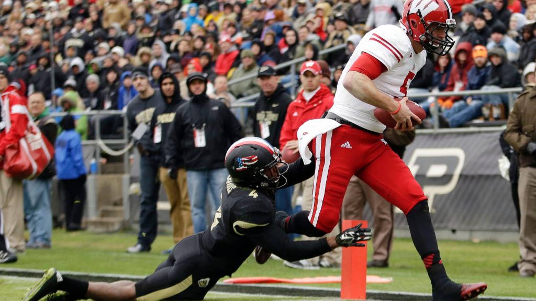 Wisconsin quarterback Tanner McEvoy, left, scores a touchdown in front of Purdue safety Taylor Richards (4) during the second half of an NCAA college football game in West Lafayette, Ind., Saturday, Nov. 8, 2014. Wisconsin won 34-16. (AP Photo/AJ Mast)