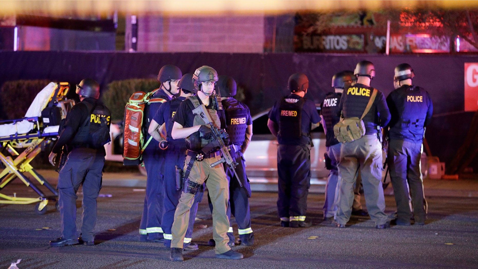 Police officers and medical personnel stand at the scene of a shooting near the Mandalay Bay resort and casino on the Las Vegas Strip, Monday, Oct. 2, 2017, in Las Vegas. Multiple victims were being transported to hospitals after a shooting late Sunday at a music festival on the Las Vegas Strip. (AP Photo/John Locher)