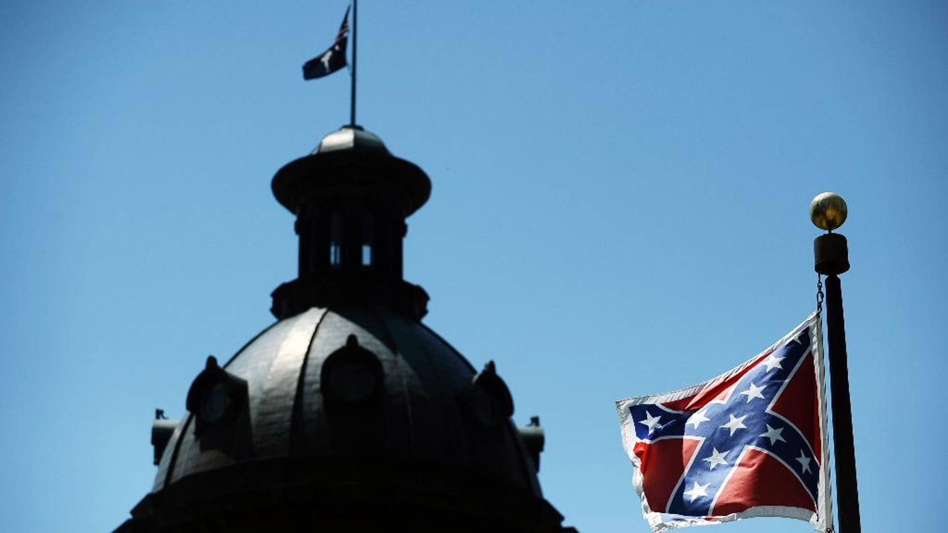 In this June 19, 2015, photo, a Confederate flag flies near the South Carolina Statehouse in Columbia, S.C. Whether South Carolina should continue to fly the Confederate flag on its statehouse grounds is the latest in a series of issues to arise this summer challenging the GOP’s effort to build the young and diverse coalition of voters it likely needs to win the White House. (AP Photo/Rainier Ehrhardt)