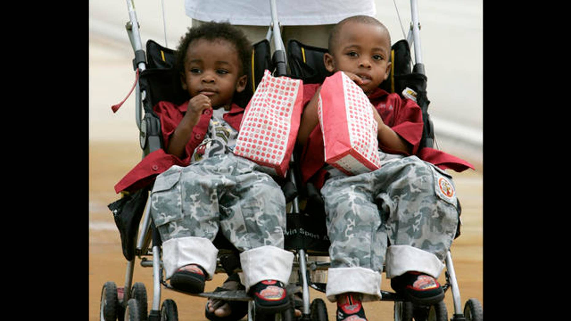 Twin brothers Chance, left, and Choice Scott enjoy their popcorn while campaigning for Democratic gubernatorial candidate Jim Davis with friends in Jupiter, Fla. Tuesday, Nov. 7, 2006. Davis is running against Republican candidate Charlie Crist. (AP Photo/Lynne Sladky)