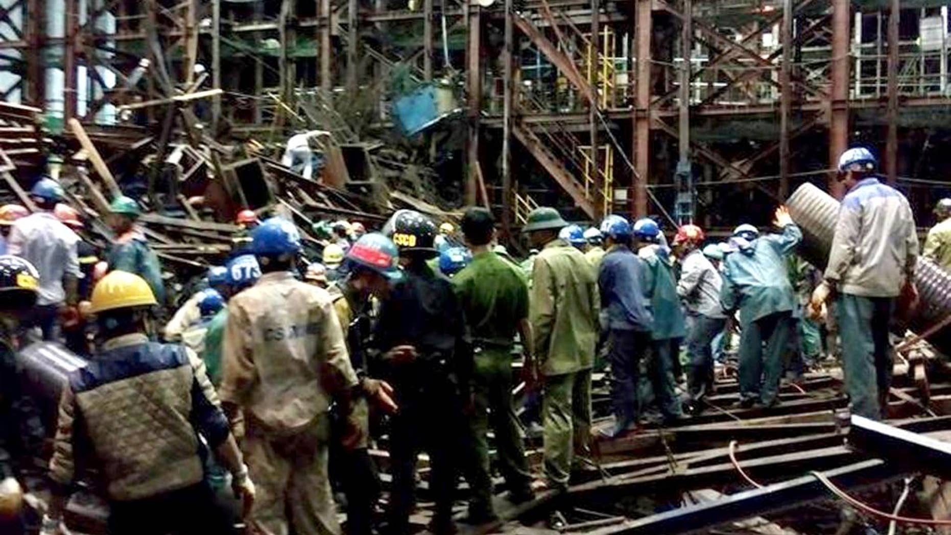 In this Wednesday March 25, 2015 photo, rescuers work through the rubble trying to find survivors after scaffolding collapsed in an economic zone in Ha Tinh province in central Vietnam. Police says at least 14 people were killed and 28 others were injured in the incident. (AP Photo/Vietnam News Agency, Cong Tuong)