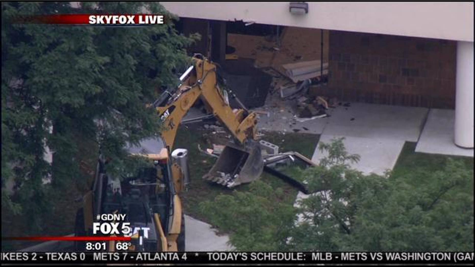 July 26, 2013: This photo shows the backhoe and damage left by a suspected thief at a Queens bank.