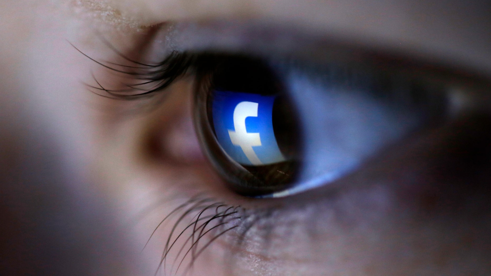 A picture illustration shows a Facebook logo reflected in a person's eye, in Zenica, March 13, 2015. (REUTERS/Dado Ruvic)