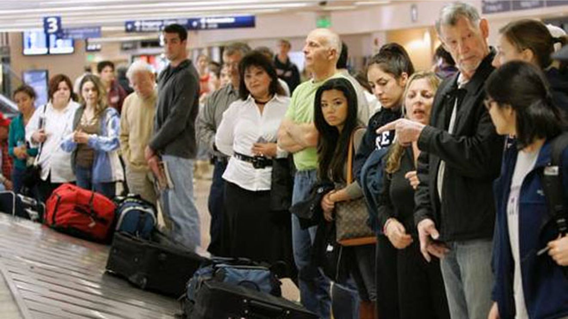 Travelers line up to get their luggage in the Southwest Airlines baggage claim at the San Jose International airport in San Jose, Calif.