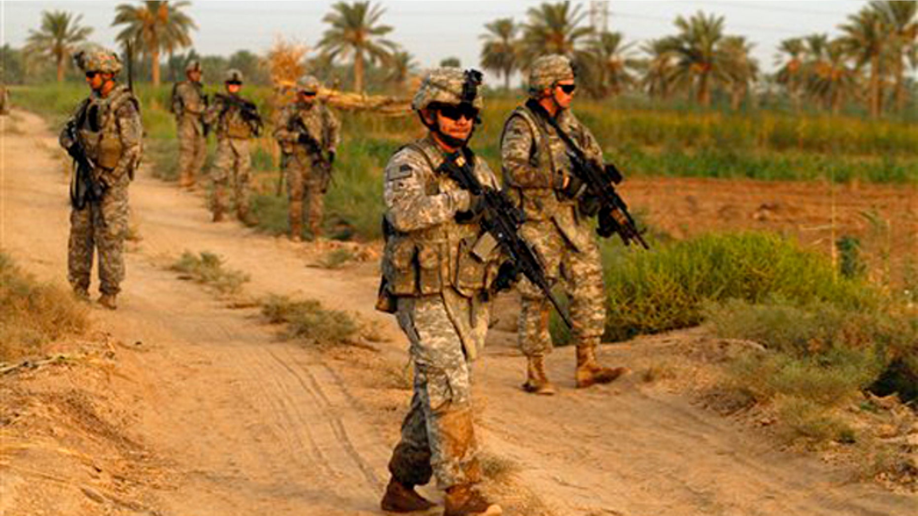 Army soldiers from 1st Battalion, 18th Infantry Regiment walk on a dirt road during an operation in Istaqlal, north of Baghdad, Iraq, Aug. 8.