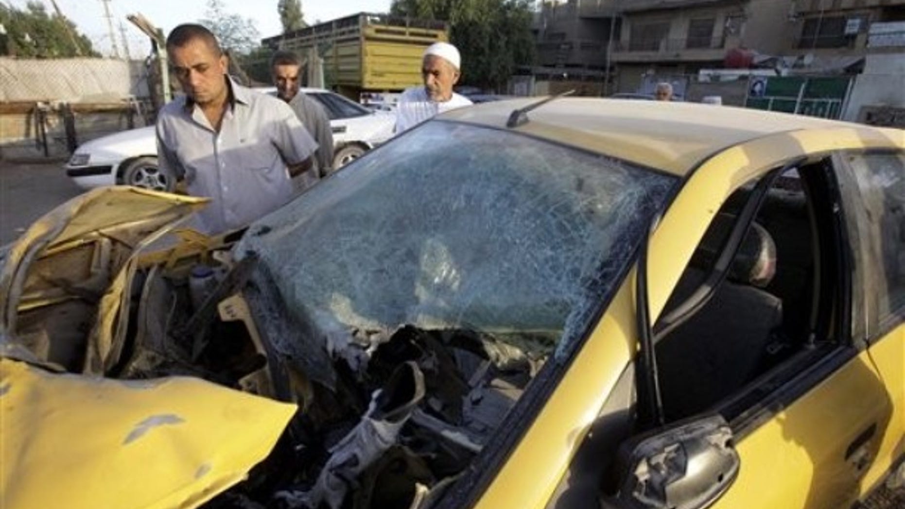 Friday: People inspect a damaged car at the scene of a bomb attack in Baghdad, Iraq. Two explosions on Thursday night in Sadr City neighborhood killed and wounded scores of people, police said.