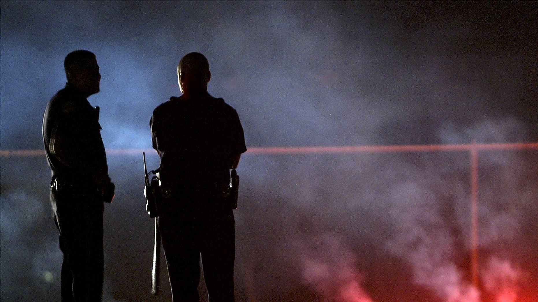 LOS ANGELES, CA - JULY 8: Bakersfield police officers stand by outside the house where five people, including three children, were murdered on July 8, 2003 in Bakersfield, California. Police are searching for the Vice Principal of a nearby elementary school as a possible suspect. (Photo by David McNew/Getty Images)