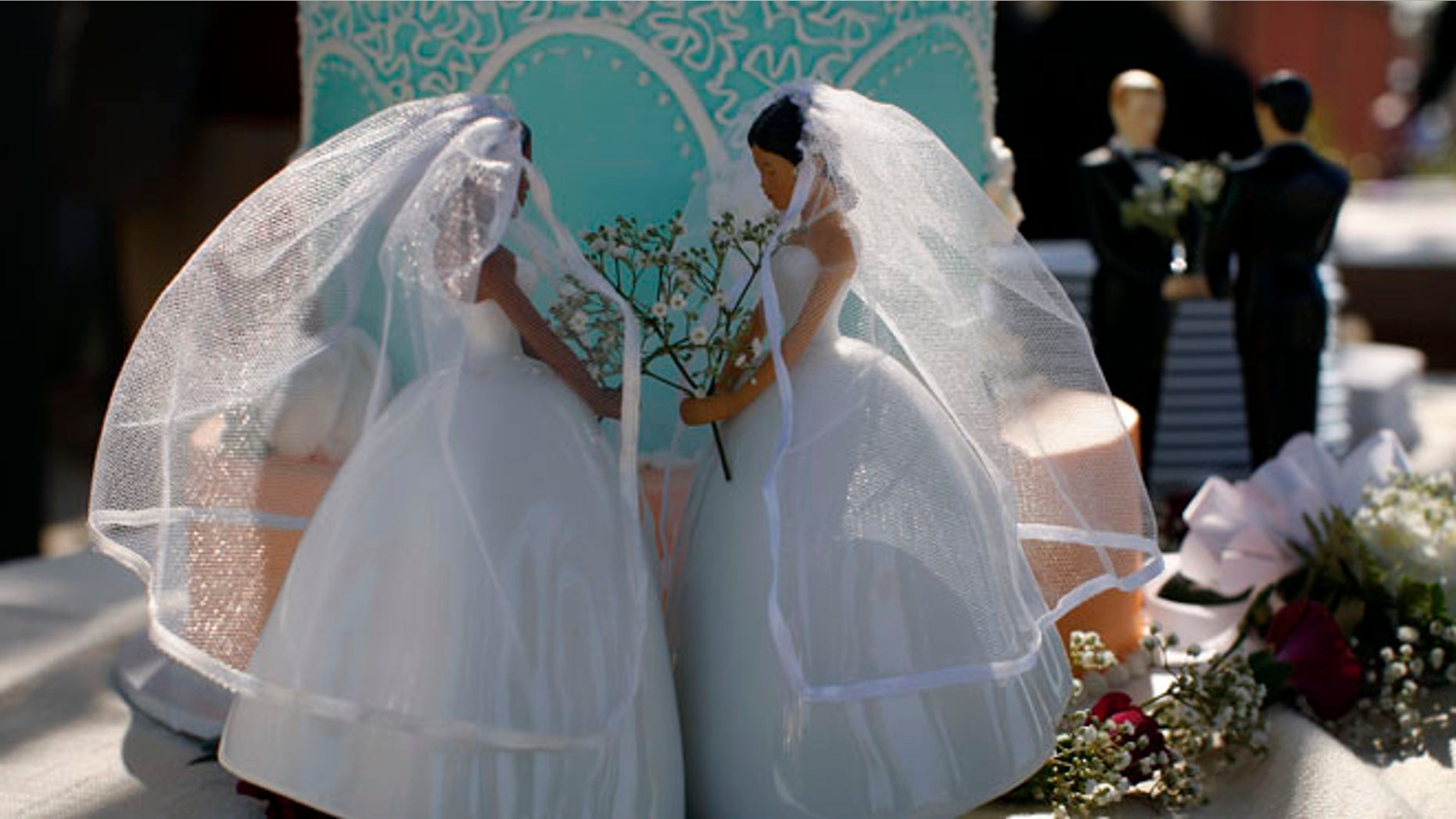 Same-sex female and male wedding cake toppers are seen outside the East Los Angeles County Recorder's Office on Valentine's Day during a news event for National Freedom to Marry Week in Los Angeles, California February 14, 2012. Same-sex marriage has not been restored in California though earlier this month the United States Court of Appeals for the Ninth Circuit declared California's ban on same-sex marriage, known as Proposition 8, unconstitutional. A 2008 California Supreme Court decision allowed same-sex couples to marry until Proposition 8 was passed. REUTERS/David McNew (UNITED STATES - Tags: SOCIETY)