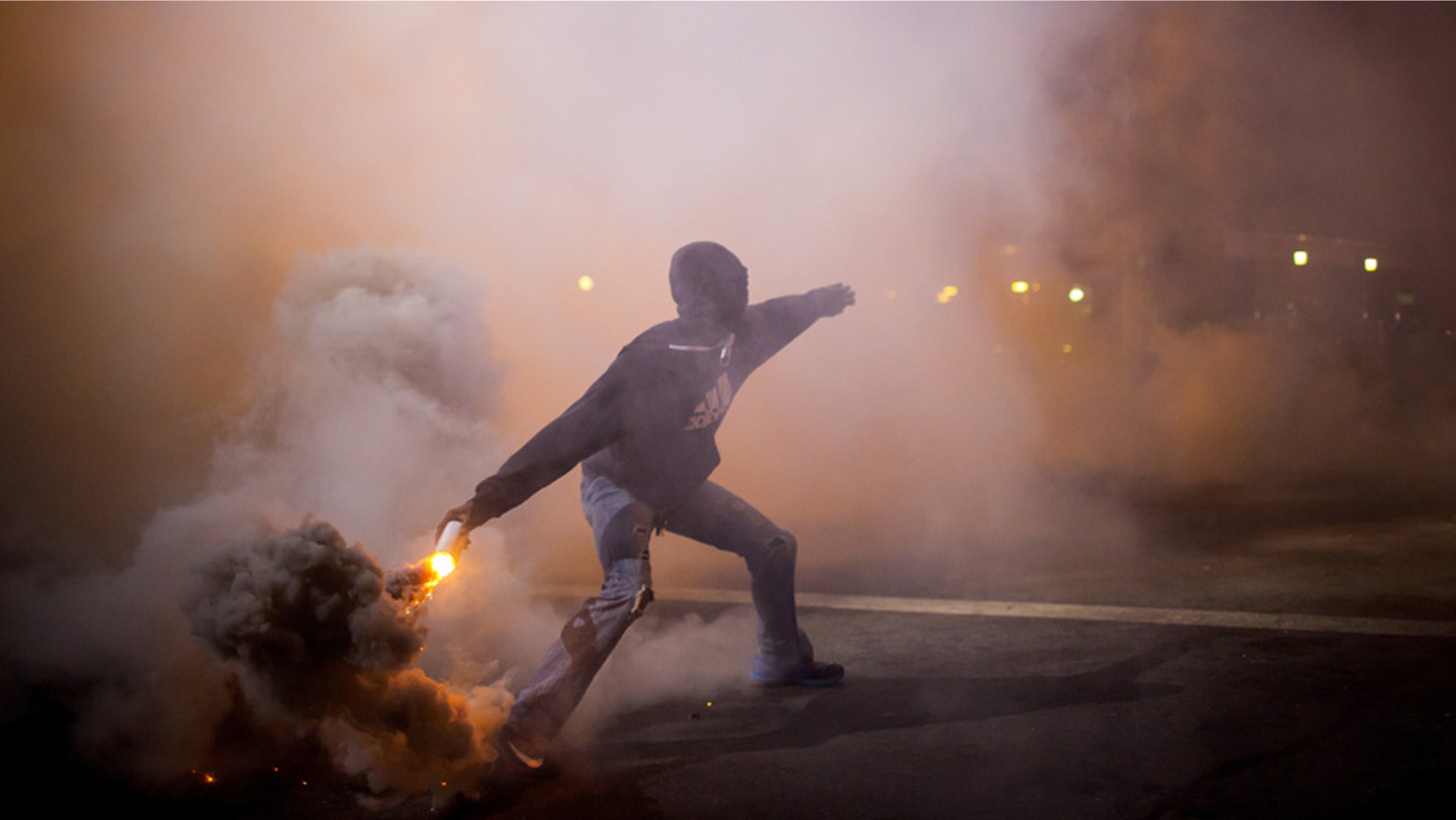 A protester throws a gas canister back at police during clashes at North Ave and Pennsylvania Ave in Baltimore, Maryland April 28, 2015. Baltimore erupted in violence on Monday as hundreds of rioters looted stores, burned buildings and at least 15 police officers were injured following the funeral of Freddie Gray, a 25-year-old black man who died after suffering a spinal injury in police custody. The riots broke out blocks from where the funeral of Gray took place and spread through much of west Baltimore. REUTERS/Eric Thayer - GF10000076849