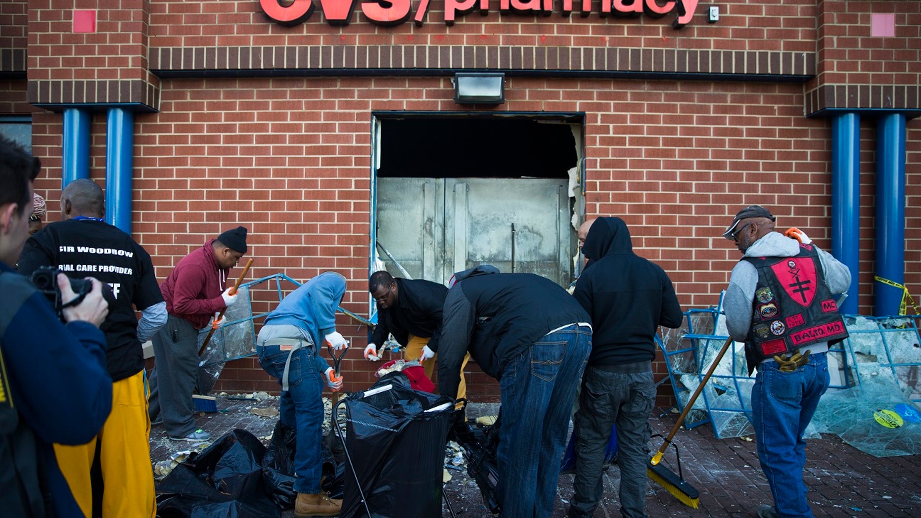 Maryland state troopers stand guard as residents clean up, Tuesday, April 28, 2015, after an evening of riots following the funeral of Freddie Gray on Monday, in Baltimore. (AP Photo/Evan Vucci)