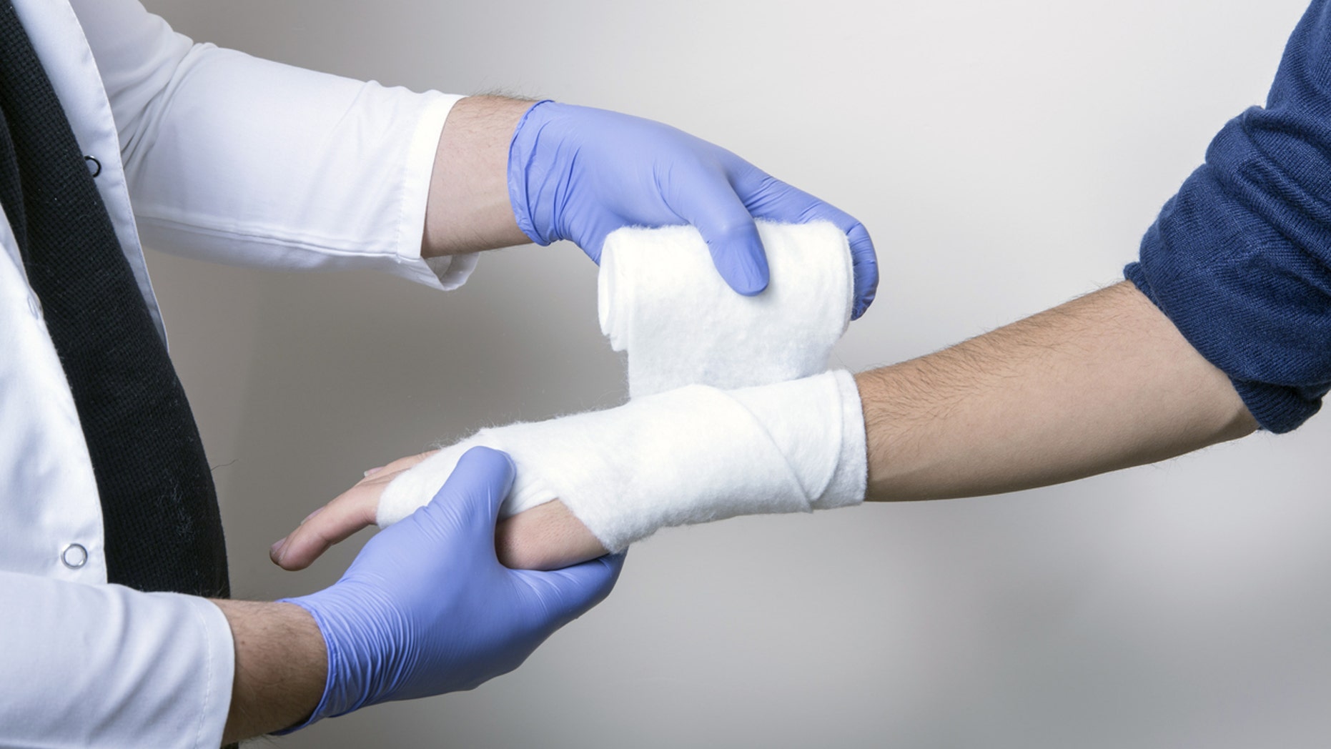 Pediatrician wraps wrist of an unidentified student.