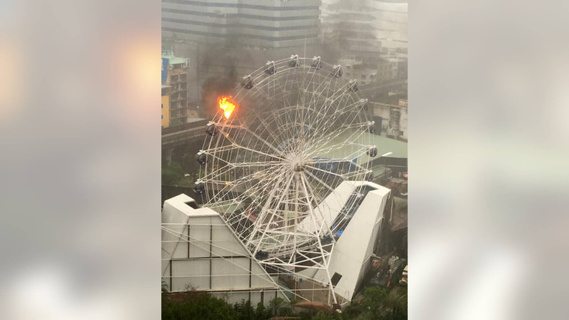 An empty passenger car of a Ferris wheel burns at Dinosaur Planet in Bangkok, Thailand on April 30, 2016.