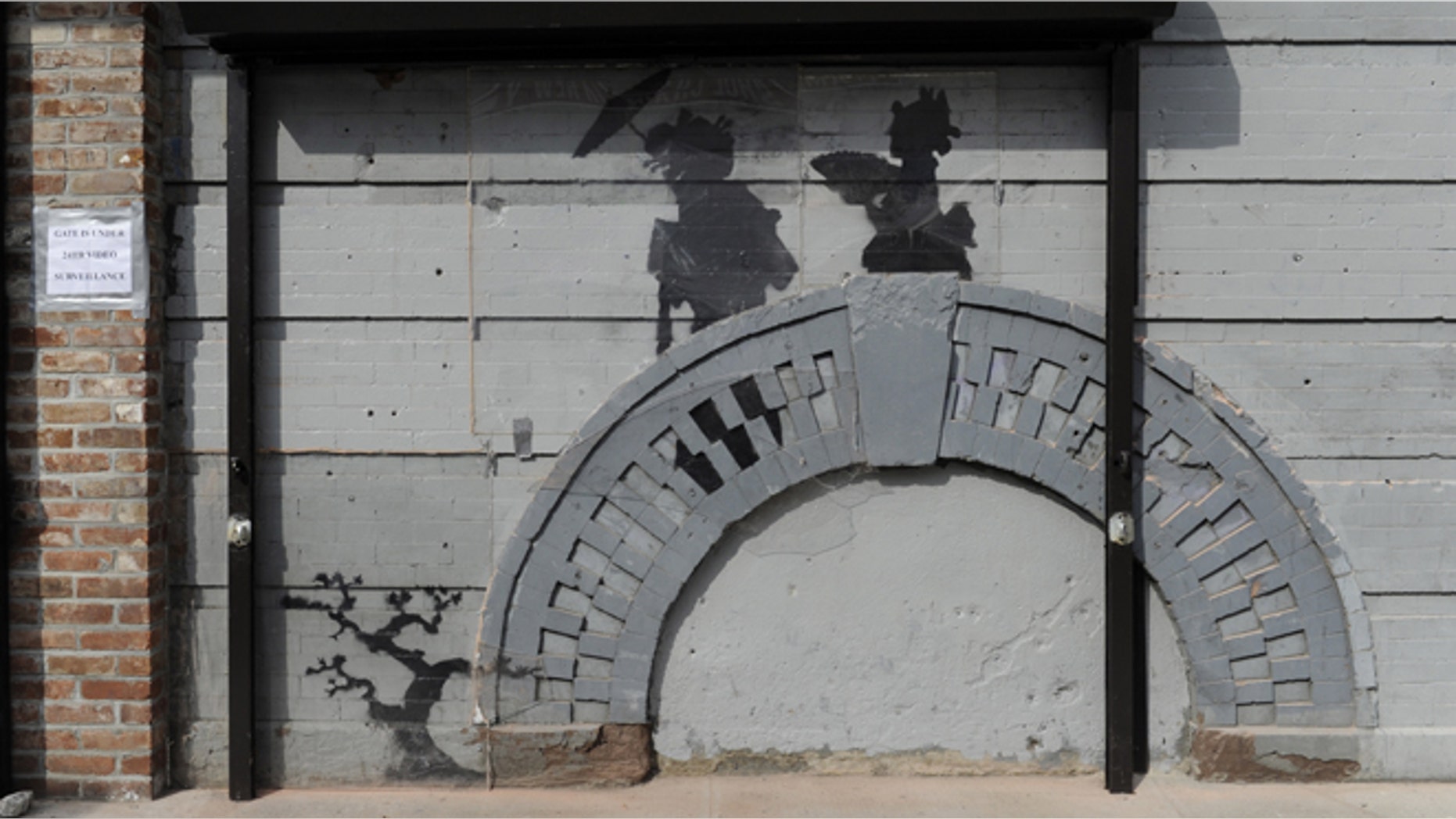 Oct. 19, 2013: Work by British graffiti artist Banksy is displayed in the Brooklyn borough of New York. The building owner has hired security guards and installed a metal gate to protect a work by Banksy. Cara Tabachnick, whose family owns the building, said the goal is to preserve the artwork "so it can be viewed and enjoyed." Most of the Banksy works that have gone up have been tagged over by others, and some have been completely erased. Mayor Michael Bloomberg said last week that graffiti ruins property and is "a sign of decay." (AP/Alyssa Goodman)