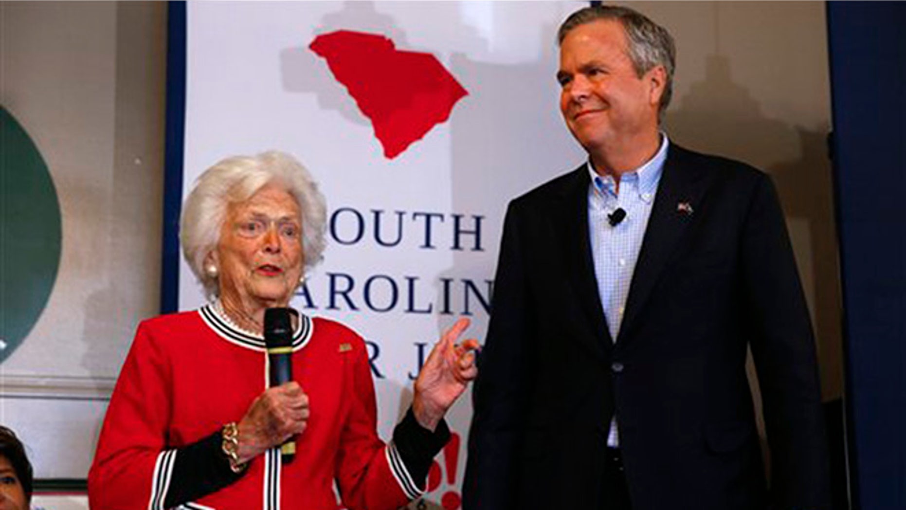Republican presidential candidate, former Florida Gov. Jeb Bush, listens as his mother, former first lady Barbara speak during a campaign stop at Wade's Restaurant, Friday, Feb. 19, 2016 in Spartanburg, S.C. (AP Photo/Paul Sancya)
