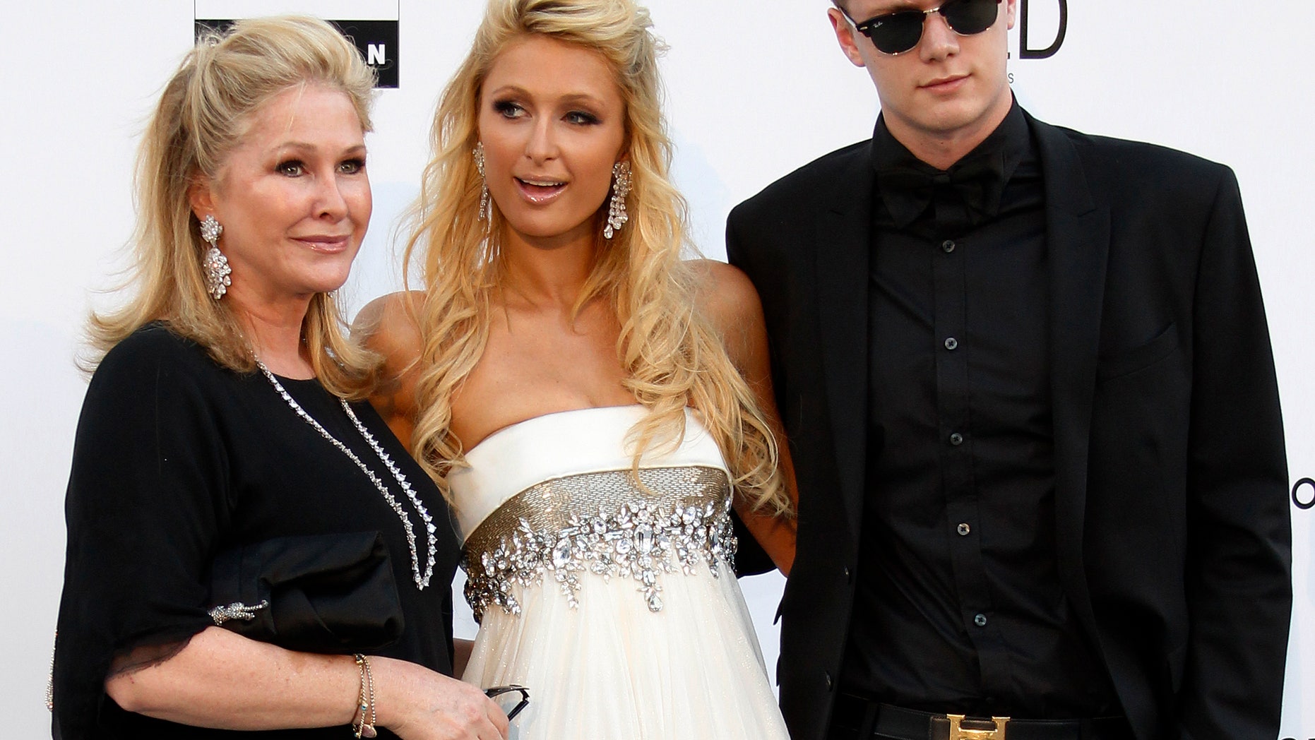May 20, 2010. Paris Hilton (C), her mother Kathy (L) and her brother Barron Nicholas Hilton arrive for the amfAR's Cinema Against AIDS 2010 event in Antibes during the 63rd Cannes Film Festival.