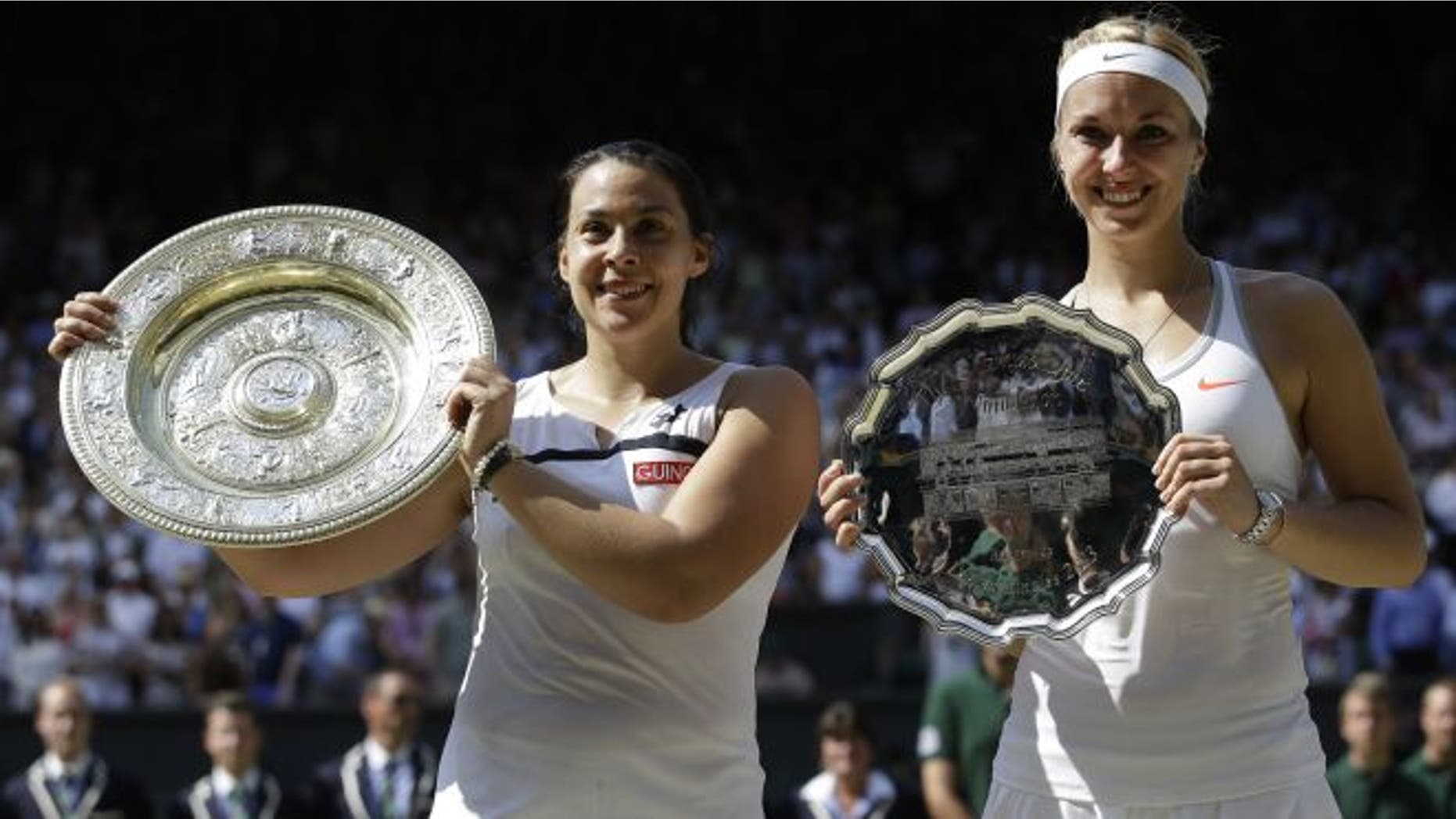 July 6, 2013: Marion Bartoli of France, left, holds her winners trophy as she stands alongside Sabine Lisicki of Germany during the trophy ceremony after the Women's singles final match at the All England Lawn Tennis Championships in Wimbledon, London. (AP)