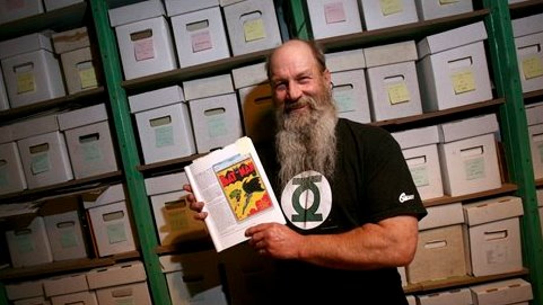 July 29: Comic book collector Mike Wheat poses with a book showing the cover of Batman No. 1 in front of boxes containing tens of thousands of comic books at his Fairbanks, Alaska home. Wheat put his copy of the 1940 Batman No. 1 on the auction block through Dallas-based Heritage Auction Galleries. (AP)
