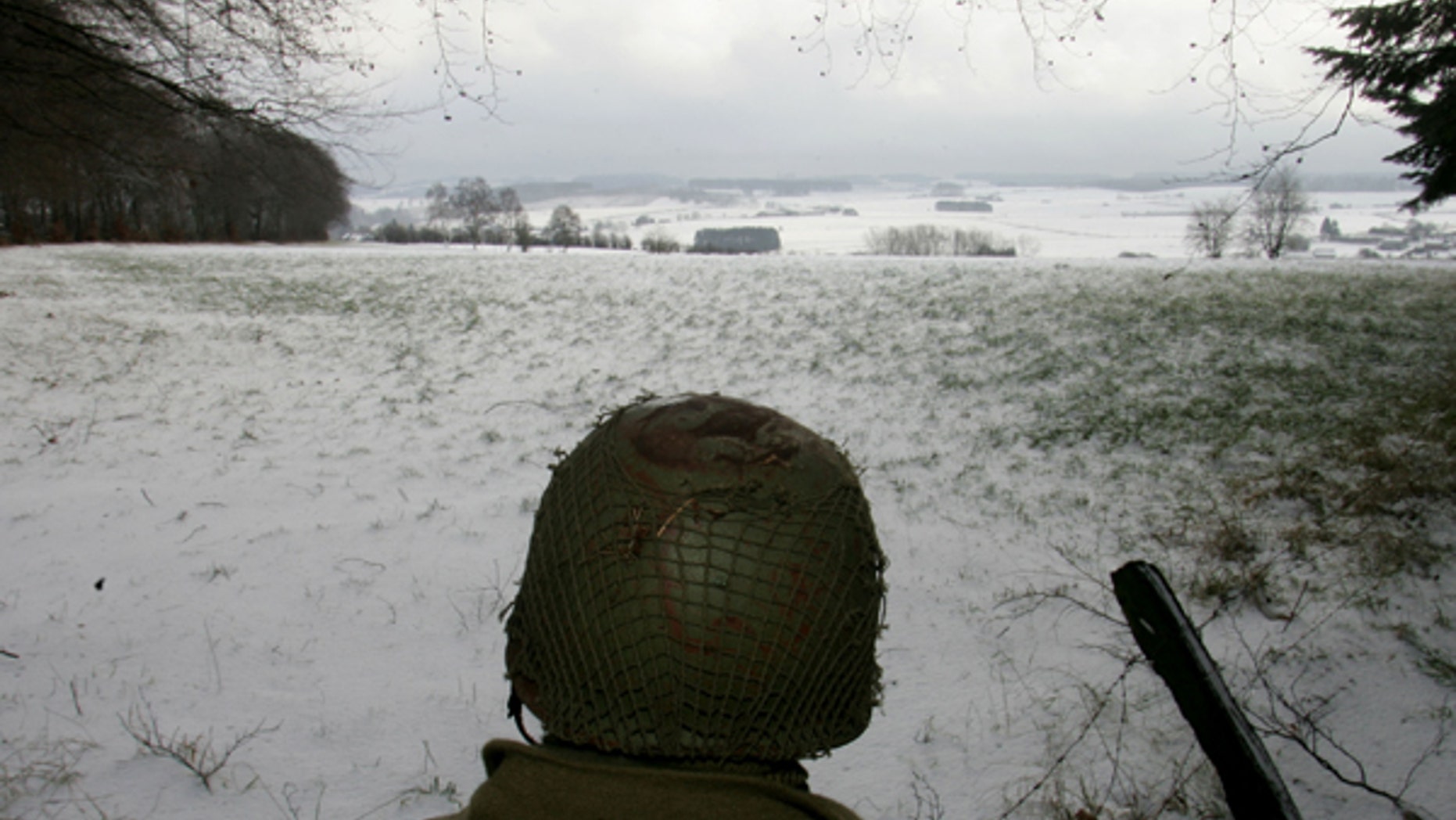 A man dressed as a U.S. soldier looks at the site of the Battle of the Bulge before a ceremony at the Mardasson World War II memorial monument in Bastogne, December 18, 2004. Belgium and Luxembourg commemorate the Battle of the Bulge, a last-ditch German offensive on December 16, 1944 which was the bloodiest land battle of WW2 involving US troops, who suffered some 80,000 casualties, of which 19,000 were killed. REUTERS/Francois Lenoir FLR/SM - RTRILAS