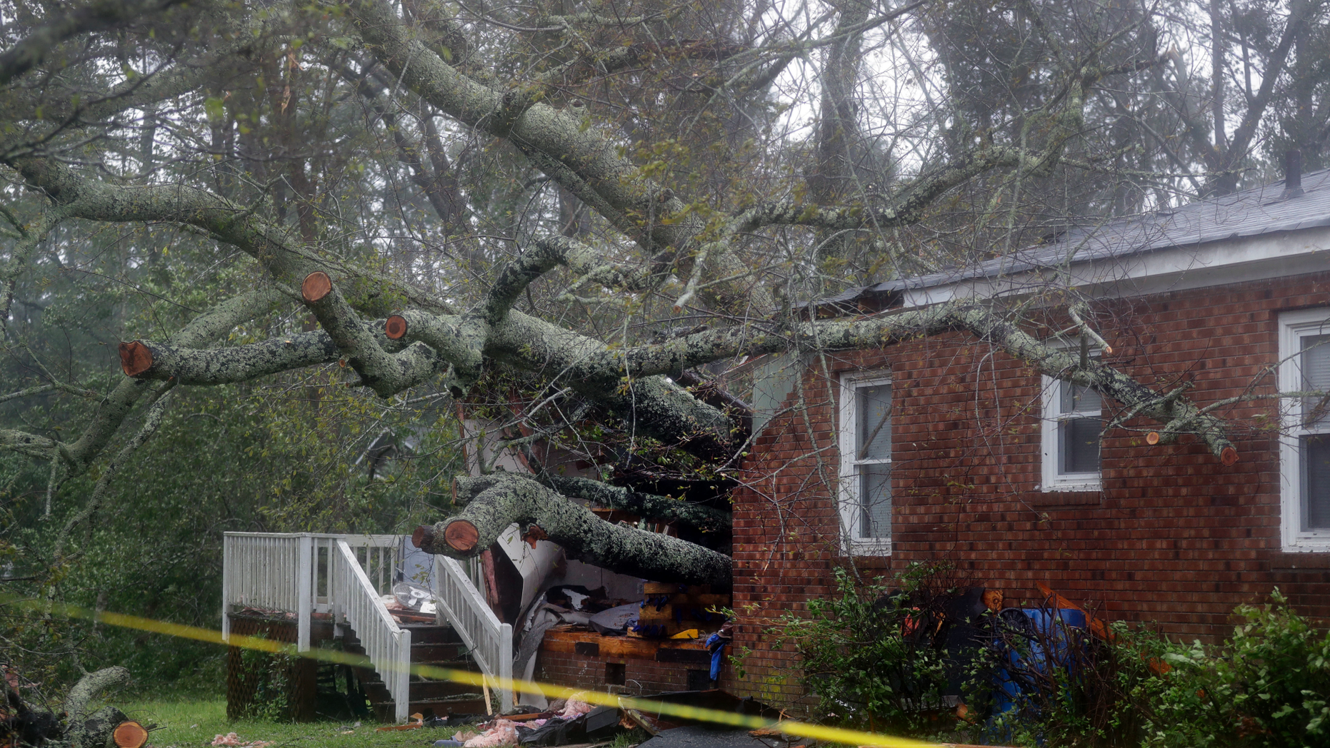 A fallen tree is shown after it crashed through the home where a woman and her baby were killed in Wilmington, N.C., after Hurricane Florence made landfall Friday, Sept. 14, 2018. (AP Photo/Chuck Burton)