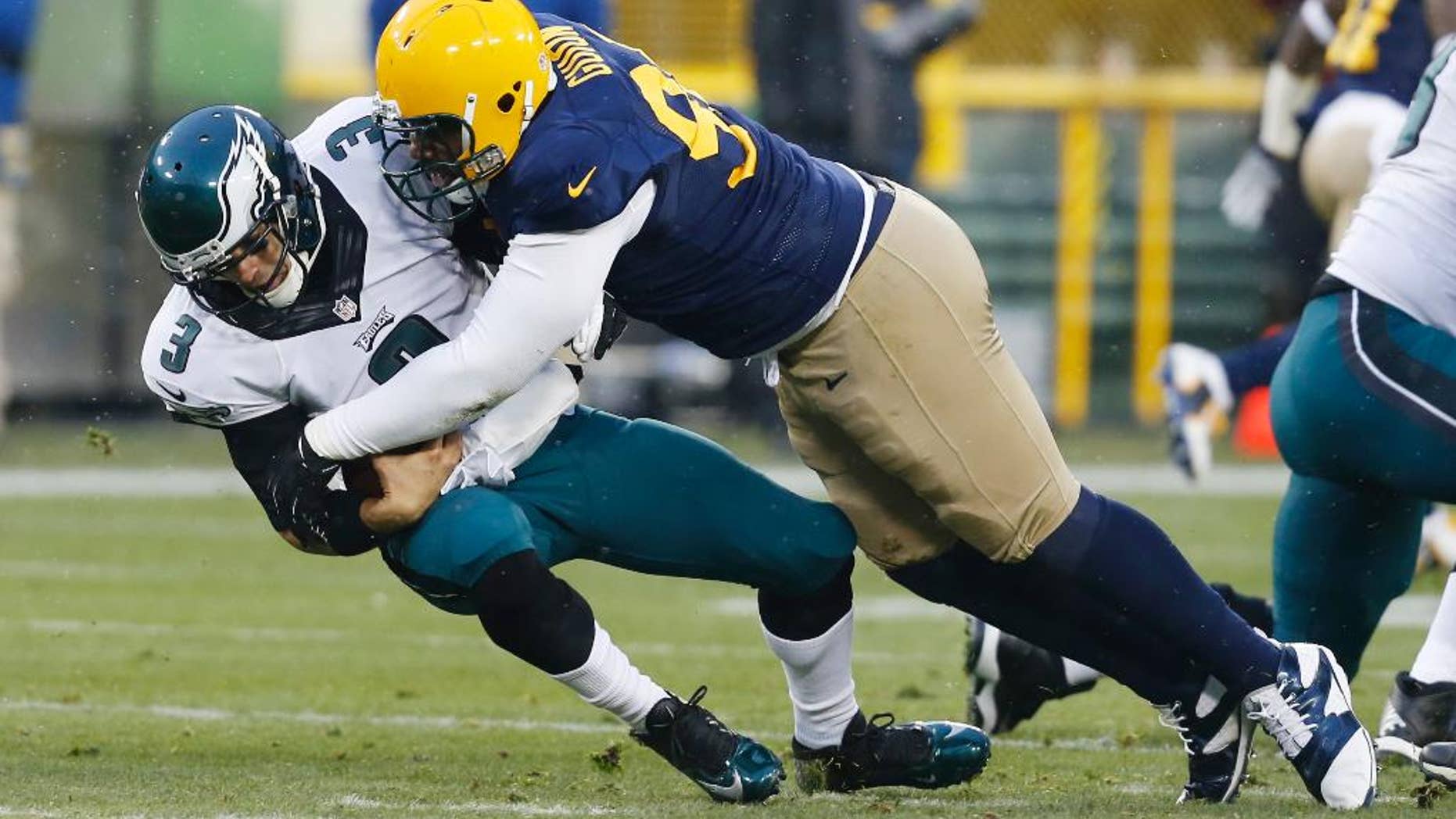 Green Bay Packers' Letroy Guion sacks Philadelphia Eagles' Mark Sanchez during the first half of an NFL football game Sunday, Nov. 16, 2014, in Green Bay, Wis. (AP Photo/Mike Roemer)