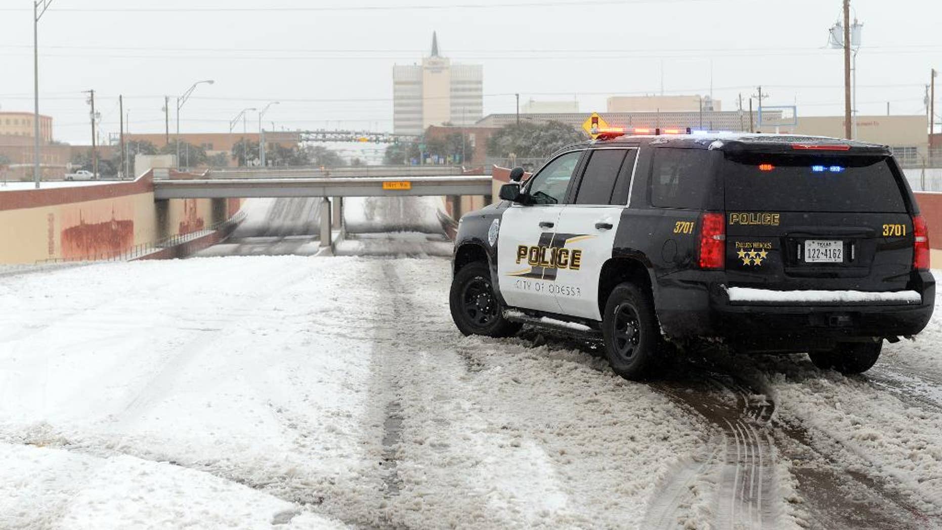 Odessa Police block access to the railroad underpass on Grant Avenue near Second Street, Sunday, Dec. 27, 2015, in Odessa, Texas. Nearly all of Interstate 40 in Texas, the main east-west highway through the Texas Panhandle, has been shut because of the snowstorm pummeling the area. The Texas Department of Public Safety says only a small section of the highway within Amarillo is not closed. (Mark Sterkel/Odessa American via AP) MANDATORY CREDIT