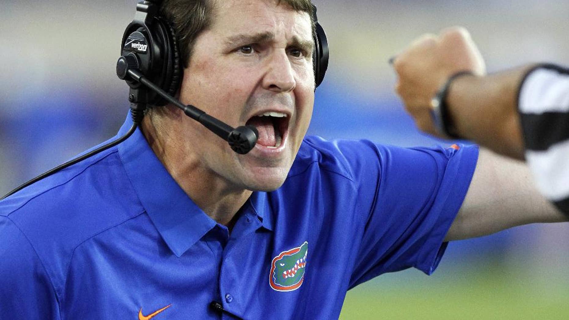 FILE - In this Sept. 28, 2013, file photo, Florida head coach Will Muschamp yells to an official in the second quarter of an NCAA college football game against Kentucky in Lexington, Ky. Muschamp came to his own defense Wednesday, Sept. 3, 2014, ripping critics who questioned his decision to reinstate three players suspended for a season opener that lasted just 10 seconds. (AP Photo/James Crisp, File)