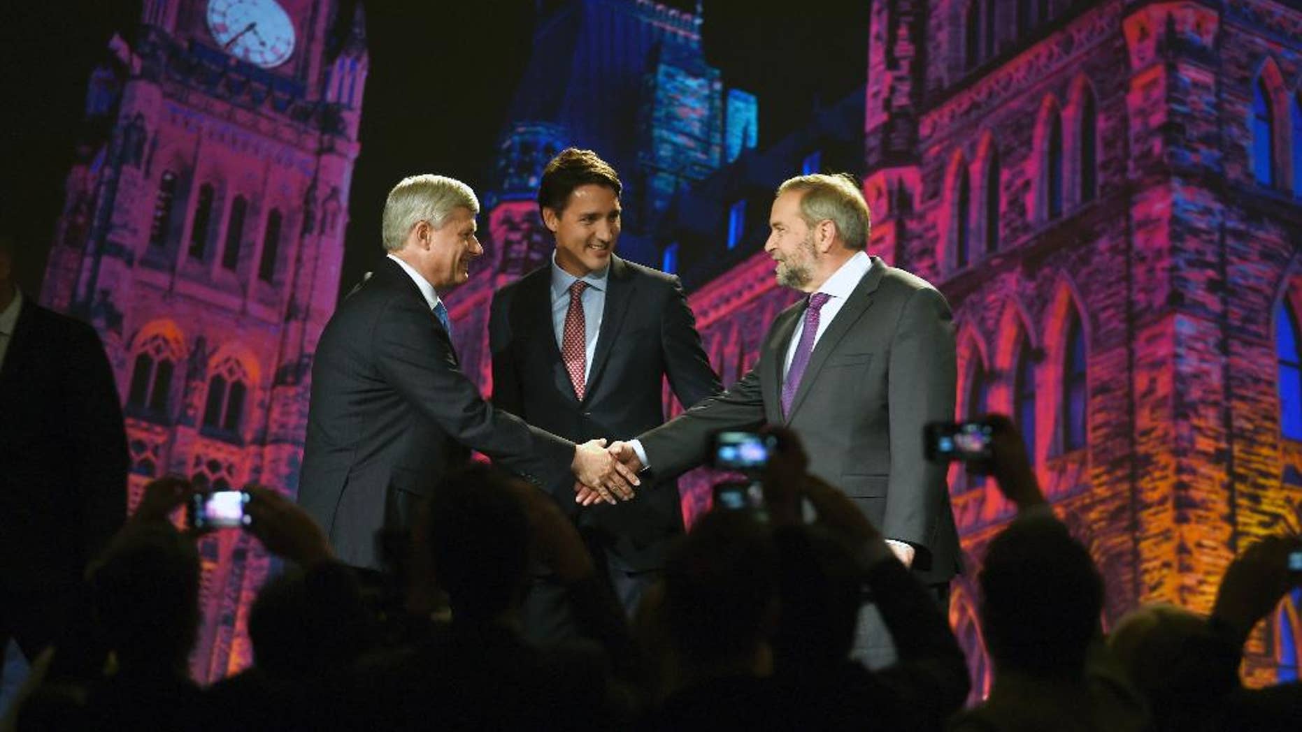 New Democratic Party leader Tom Mulcair, right, shakes hands with Conservative Prime Minster Stephen Harper, left, as Liberal leader Justin Trudeau, center, looks on during their introduction prior to a debate, Thursday, Sept. 17, 2015 in Calgary, Alberta. (Sean Kilpatrick/The Canadian Press via AP) MANDATORY CREDIT