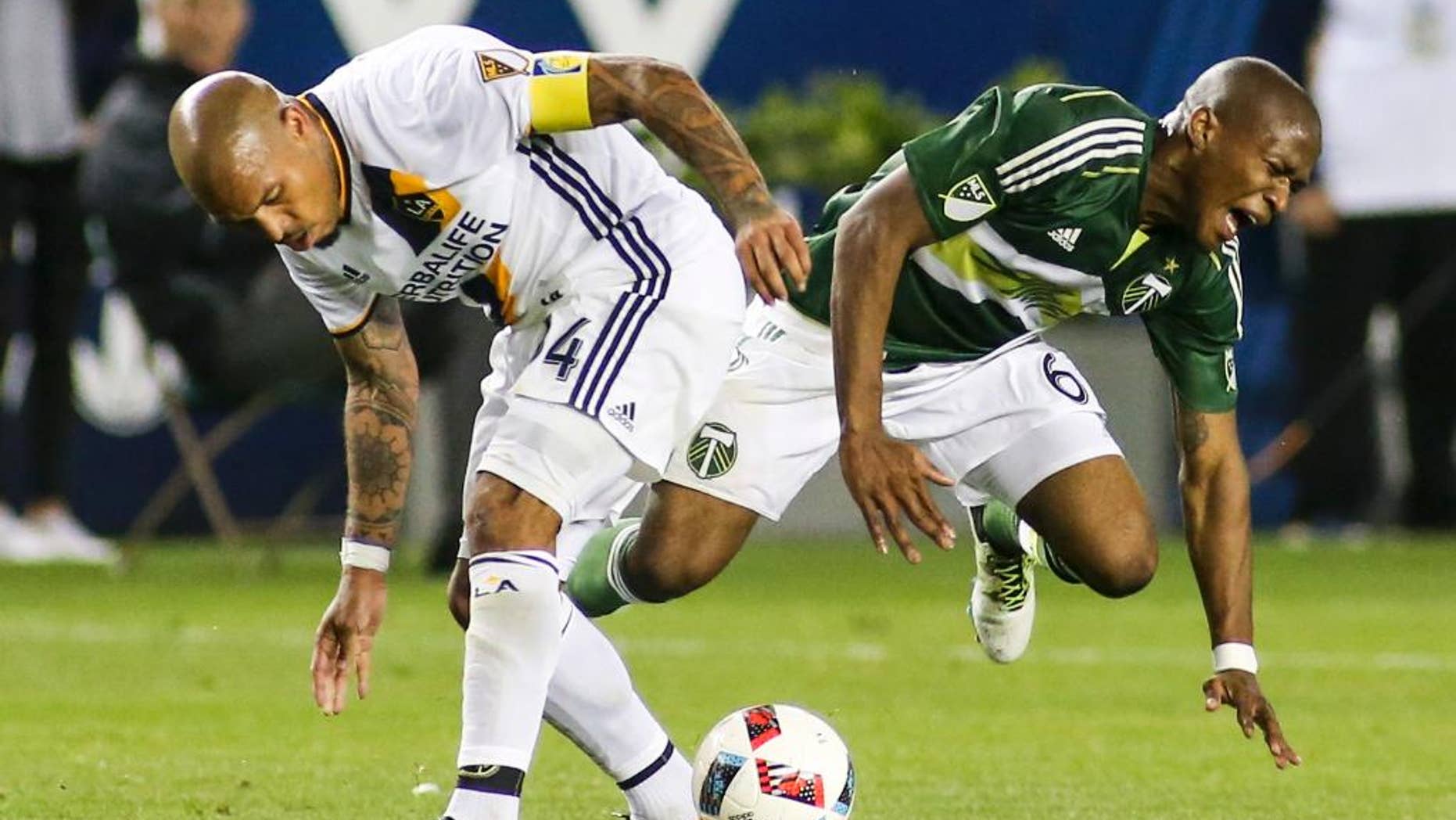 Los Angeles Galaxy midfielder Nigel de Jong, left, crashes into Portland Timbers midfielder Darlington Nagbe during the second half of an MLS soccer game in Carson, Calif., Sunday April 10, 2016. The game ended in a 1-1 draw. (AP Photo/Ringo H.W. Chiu)